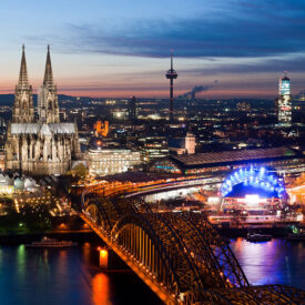 Luftaufnahme von Köln mit Dom, Rhein und beleuchteter Altstadt bei Nacht
